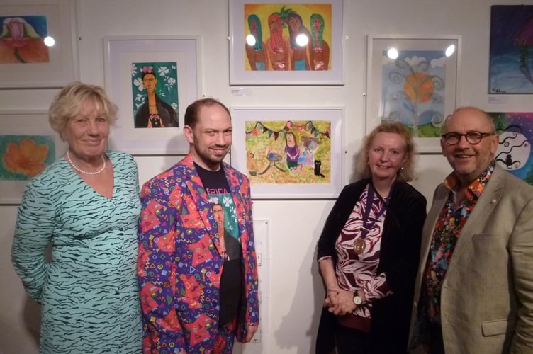 From left: Jackie Coulson (mum), Olly Coulson (artist), Ginny Boxall (Alton deputy town mayor) and John Coulson (dad) at private viewing of Through Olly’s Eyes art exhibition at the Allen Gallery in Alton on February 4, 2022. Picture they are standing next to is called The Happy Knitters.