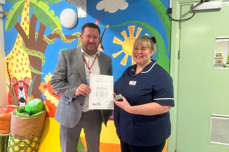 Hannah Thomson, senior sister at Hampshire Hospitals, is presented with her Queen's Nurse certificate and pin badge by Justin Wright, child health lead for integrated community services at Hampshire Hospitals, February 2025.